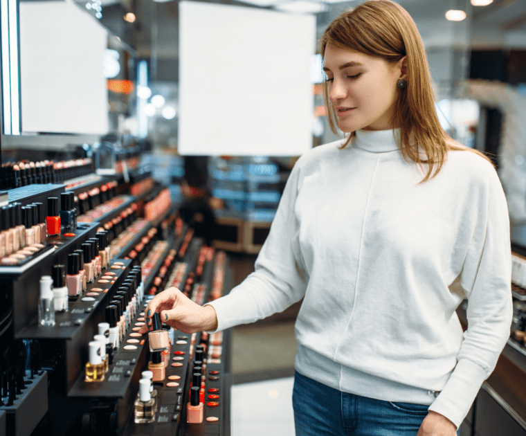 A woman choosing nail polish in a drugstore