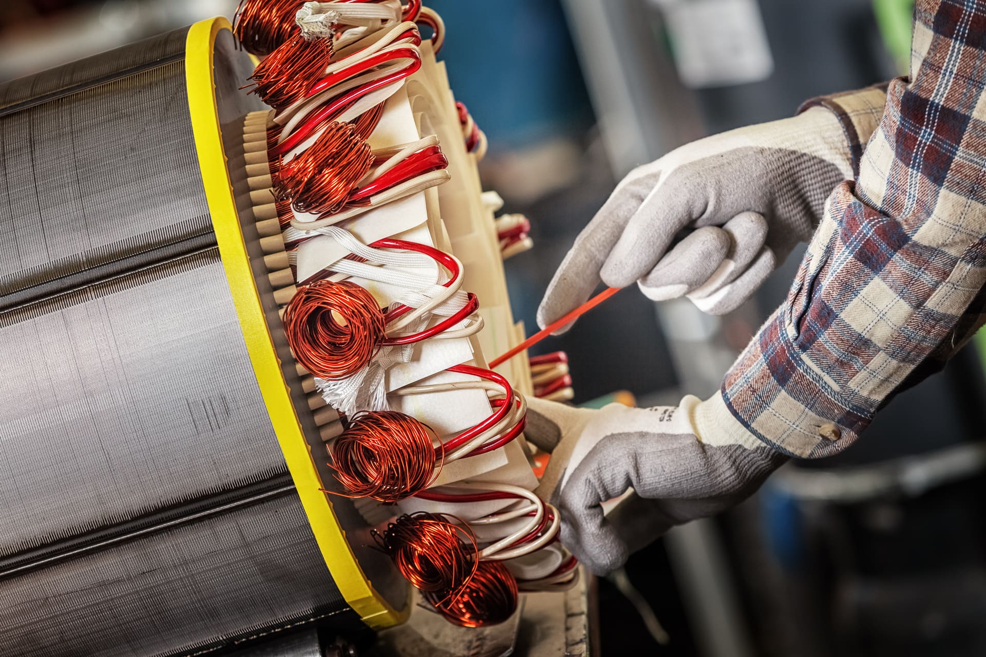 A gloved worker is focused on a machine