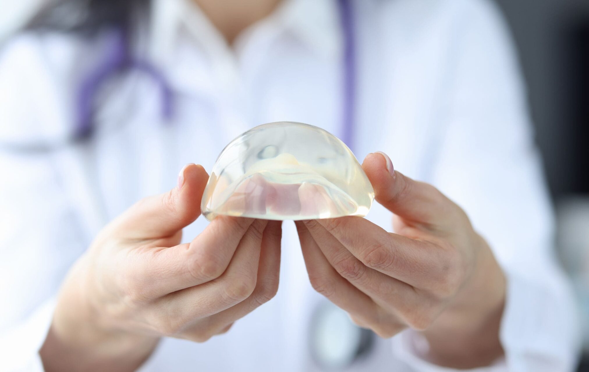 A woman holds a plastic object