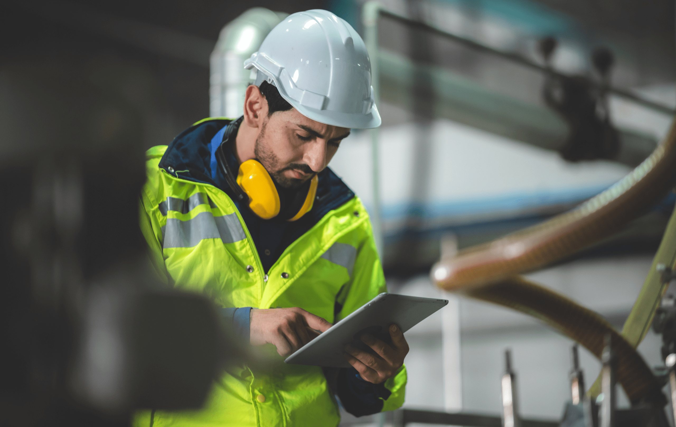 Employee in a reflective vest reading a tablet