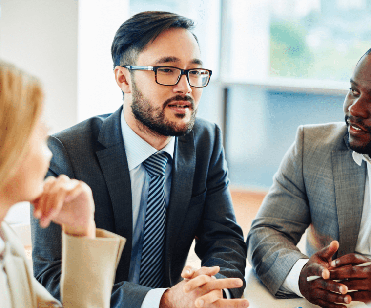 Three business people engaged in conversation at a table