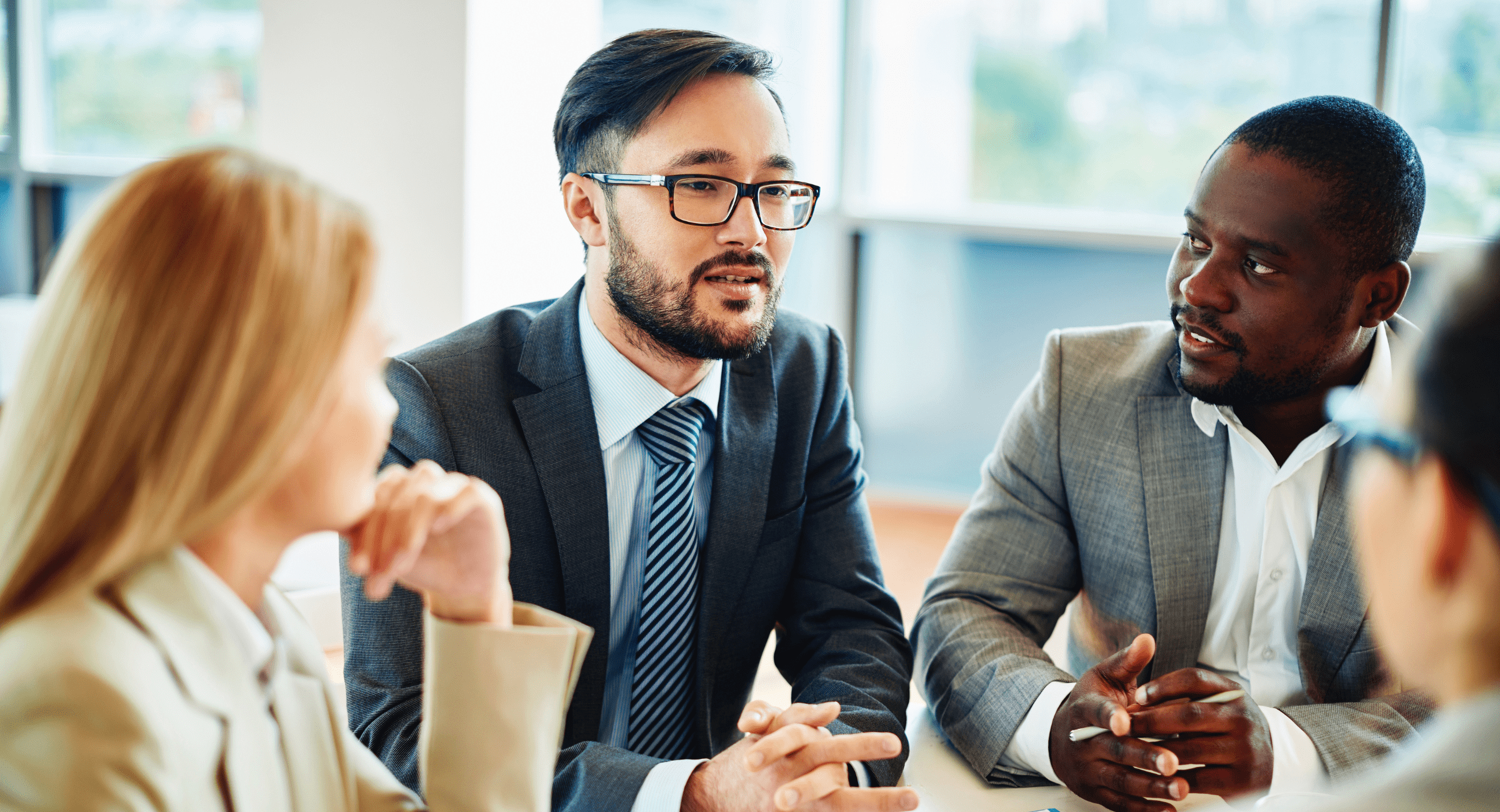 Three business people engaged in conversation at a table