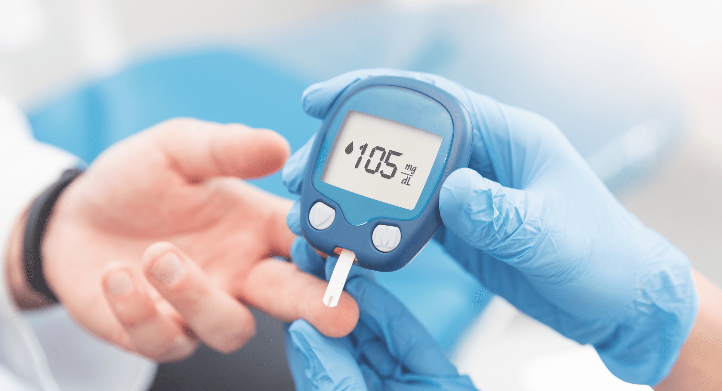 Blue-gloved hands hold a blood glucose meter