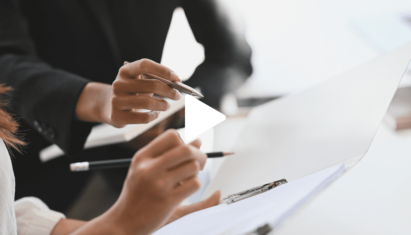 A business individuals engaged in writing on paper, showcasing concentration and professionalism in an office setting.