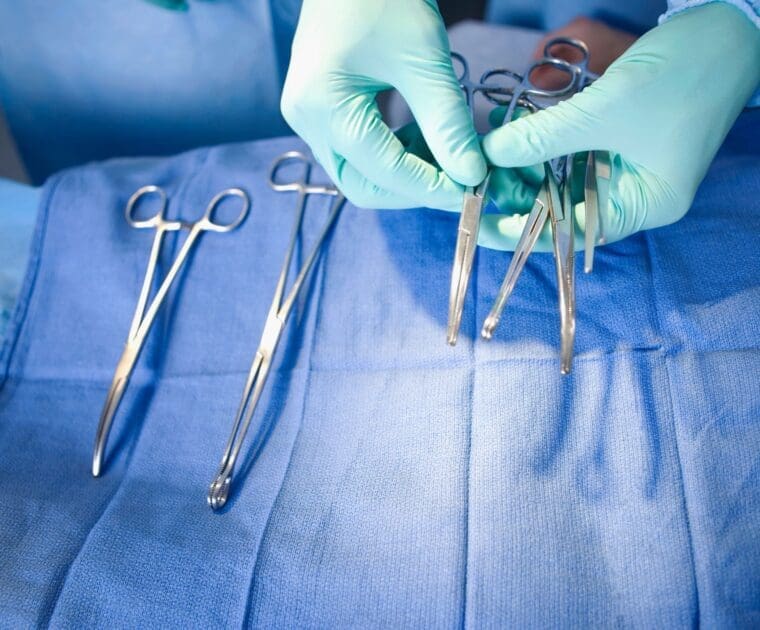 A person holds surgical scissors