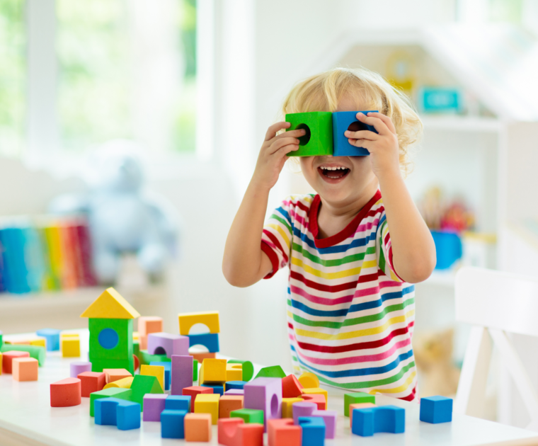 Kid playing with wooden colorfull blocks